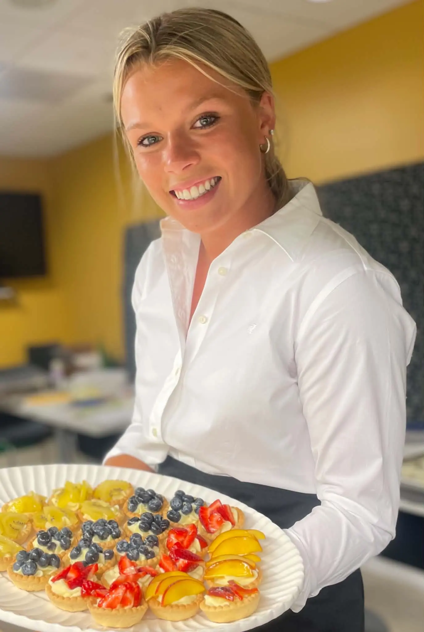 Le Personal Chef team member holding a platter of fruit pastries