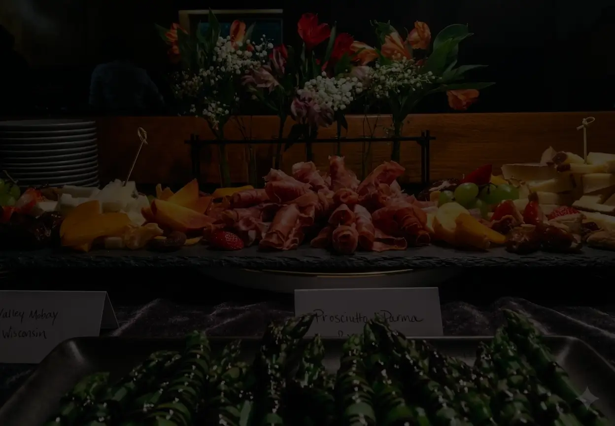 A chef pouring sauce tableside in a dimly lit dining room